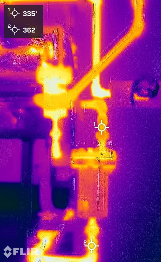 FLIR thermal image of a failed-open steam trap: downstream piping glowing hot at 335 to 362 degrees Fahrenheit, showing live steam blowing through the trap